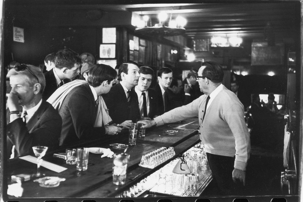 Monochrome, crowd of suit wearing white men at a bar